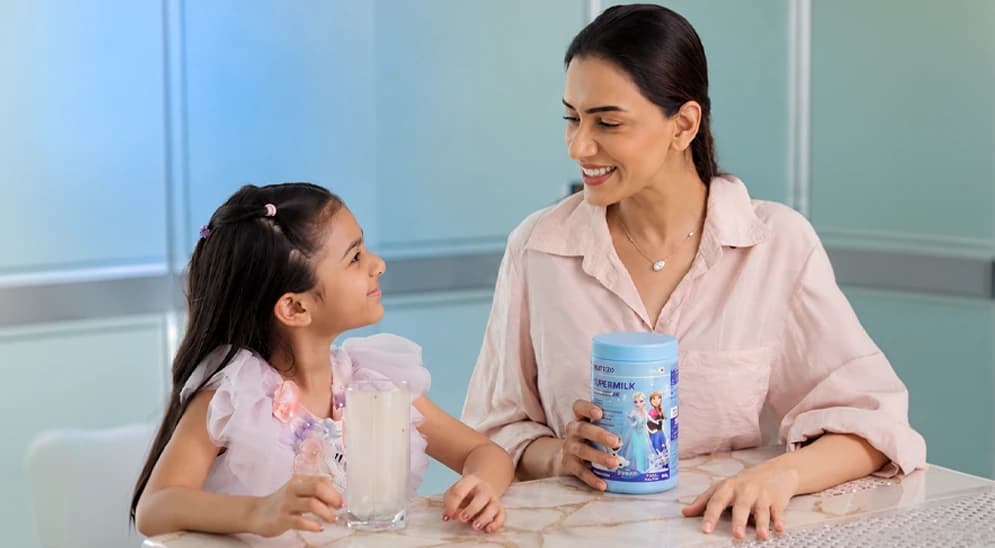 A mother and daughter sharing a Supermilk tub at a table